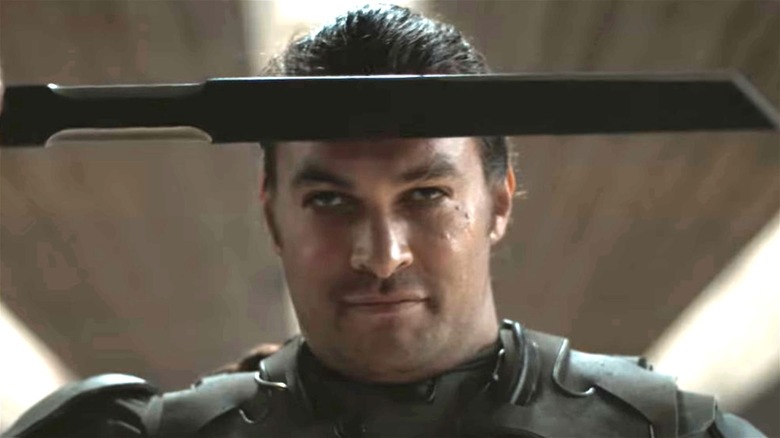 Jason Momoa holding sword against forehead