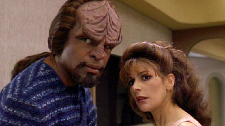 Worf and Troi look down corridor